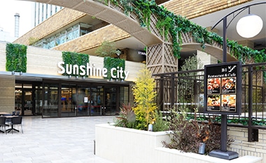 池袋サンシャインシティの写真。奥にSunshine cityの看板。その下に入口。手前は広場になっていてその前にアーチがある。