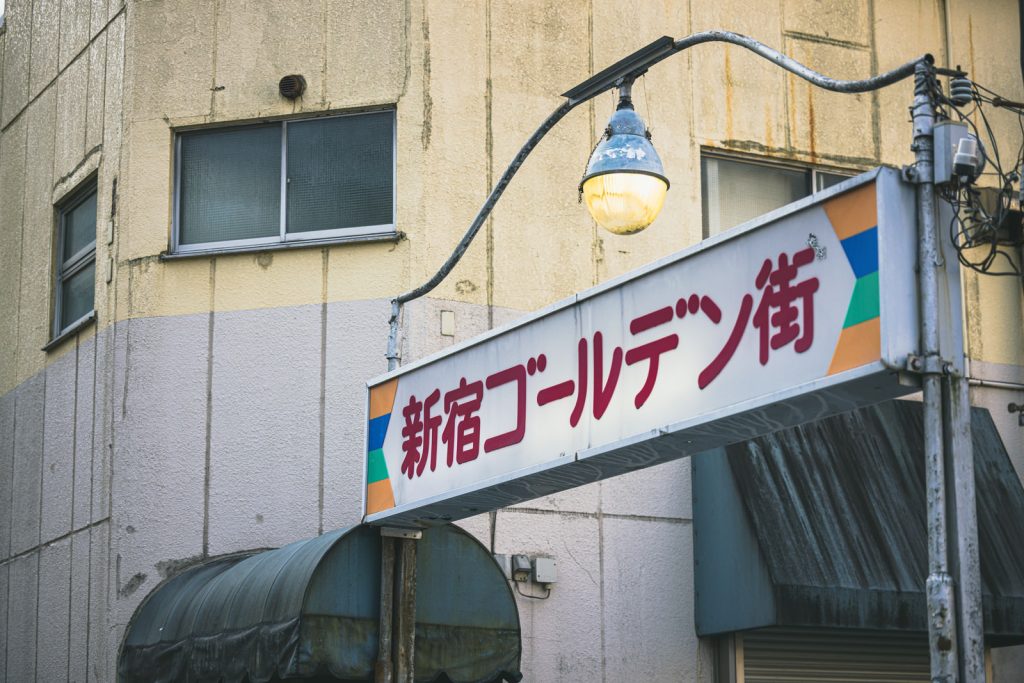 新宿ゴールデン街の商店街入口看板の写真。看板の上にはライトがある。